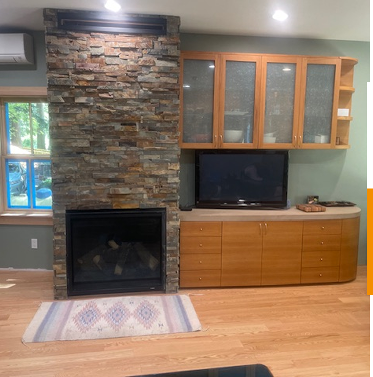 Fireplace with stone chimney and cabinets.